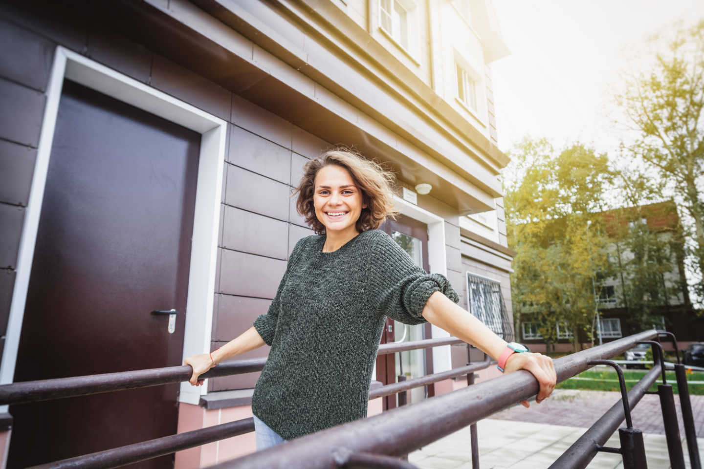 Young happy beautiful woman on the background of the entrance to